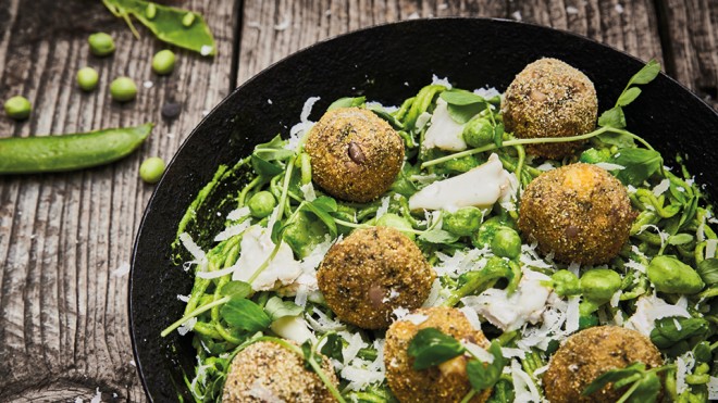 Summer Pea Linguini with Goats Cheese and Polenta Fritters served in a black pan on a wooden table