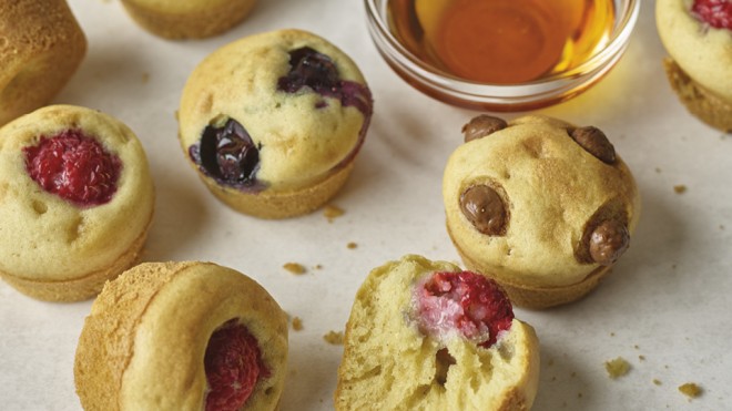 Mini Pancake Bites with various friut and chcolate fillings next to a bowl of maple syrup