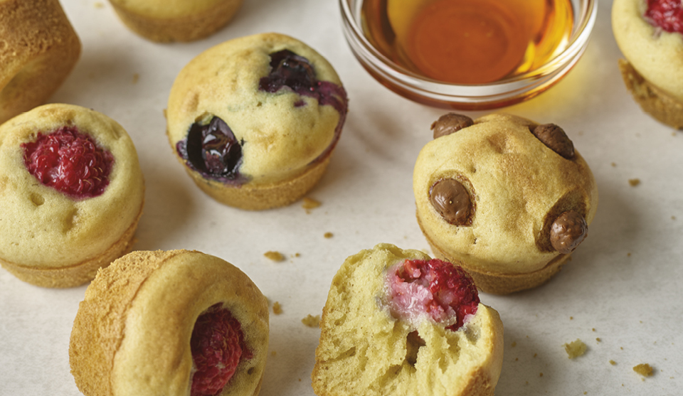 Mini Pancake Bites with various friut and chcolate fillings next to a bowl of maple syrup