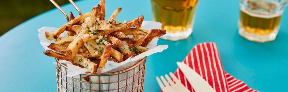 Parmesan and truffle fries served in a basket with wooden cutlery