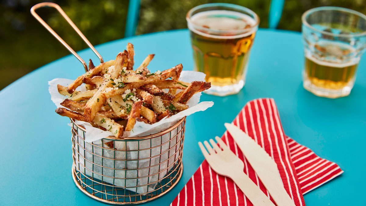 Parmesan and truffle fries served in a basket with wooden cutlery