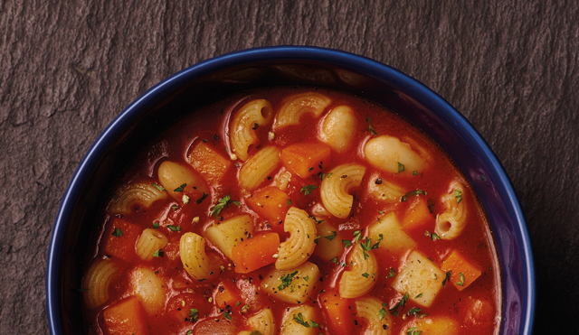 Pasta and Bean Soup served in a blue bowl topped with chopped parsley