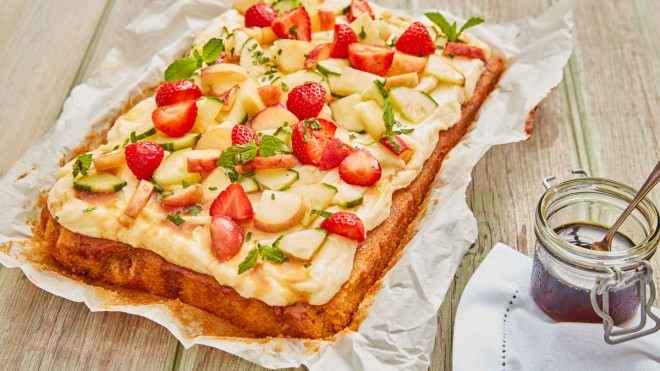 Pimm's Traybake served on baking parchment next to a jar of Pimm's syrup