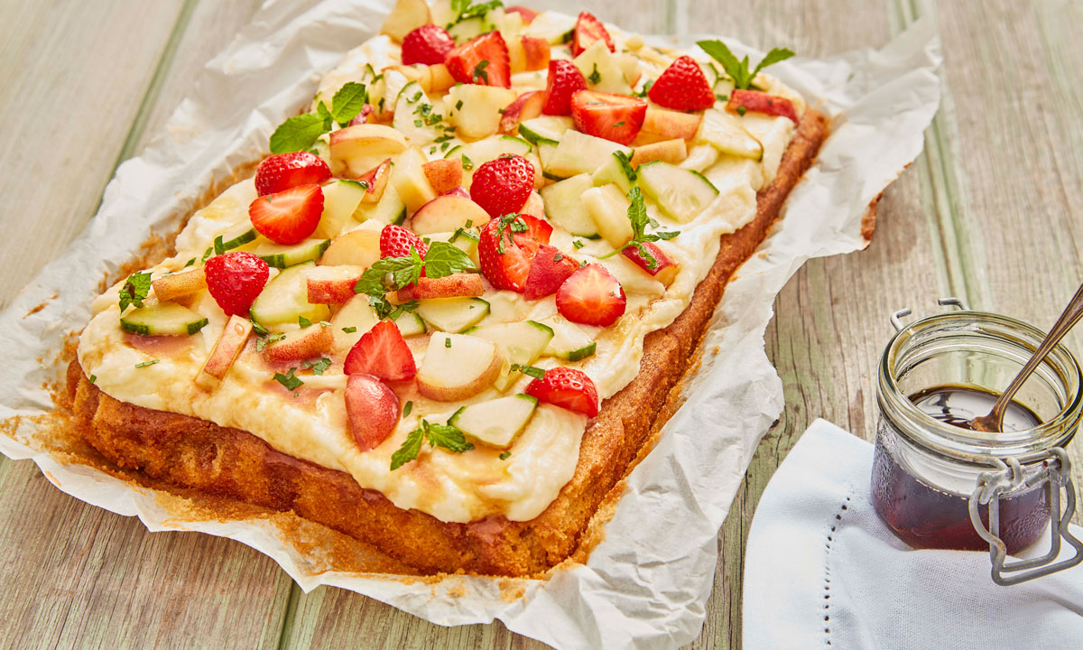 Pimm's Traybake served on baking parchment next to a jar of Pimm's syrup