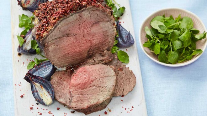 Roast Topside of Beef with Pink Peppercorn Crust served sliced on a white board