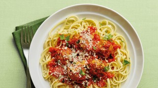 Herby Pork Meatballs with Linguine, served on a white plate, topped with parsley and Parmesan cheese