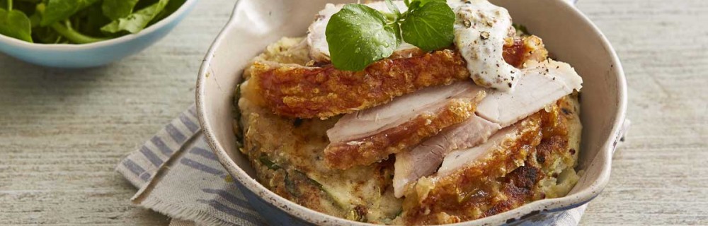 Potato and Apple Cakes with Leftover Roast Pork served in a casserole dish on top of a striped table cloth