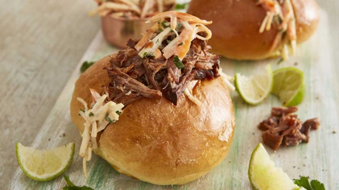 Pulled Beef and 'Slaw Butty, served on a wooden board, with wedges of lime