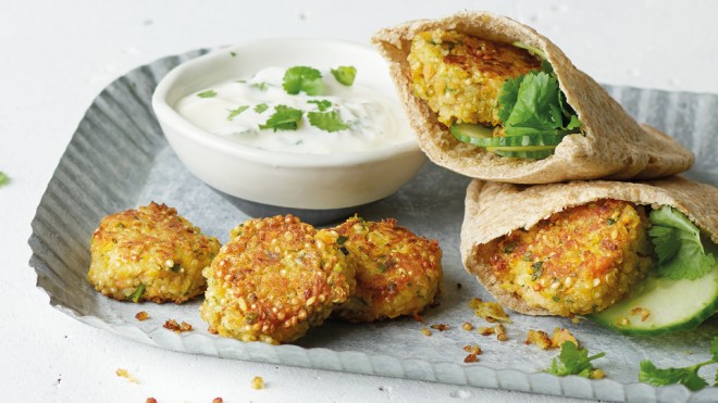 Spiced Quinoa Falafel served in pitta breads on a blue dish with a lemon and yoghurt sauce