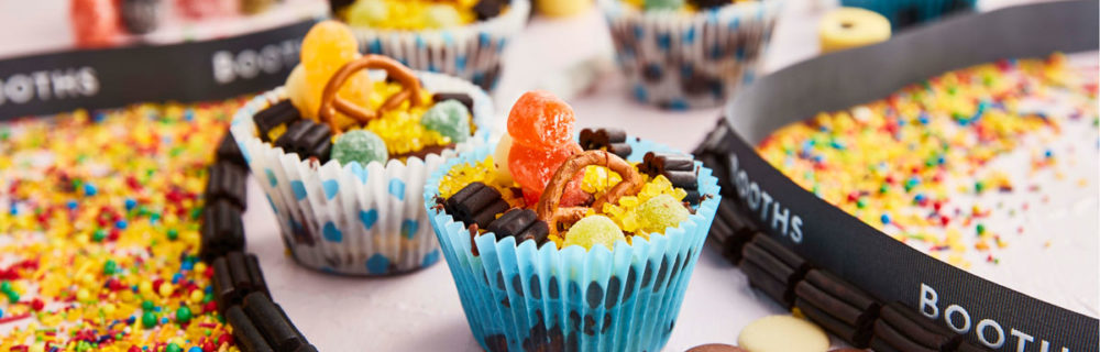 Chocolate Tiffin Race Cars surrounded by sprinkles and chocolate buttons