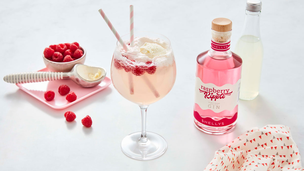 Raspberry Ripple Gin Float served in a gin glass, with Shelly's raspberry ripple, fresh raspberries and an ice cream scoop