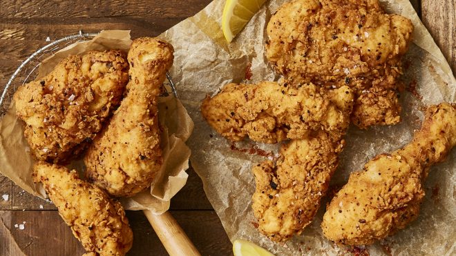 Southern Fried Chicken served on baking parchment with wedges of lemon