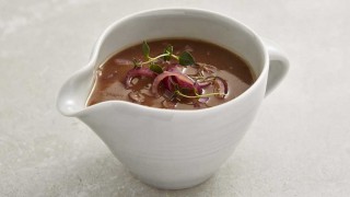 Red Onion Gravy served in a white pouring jug