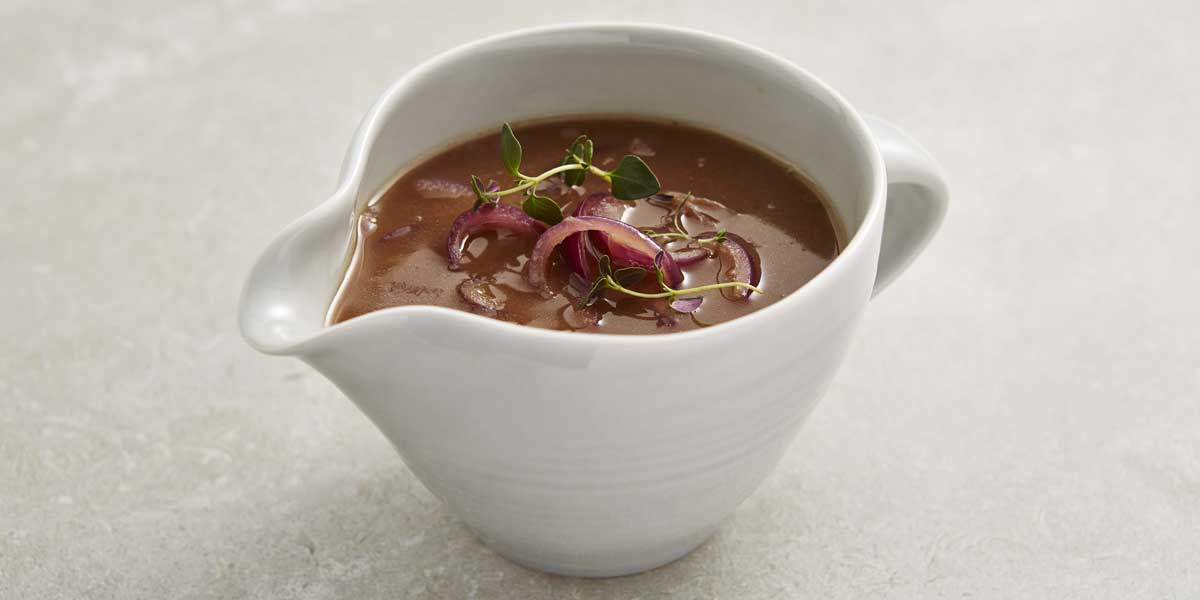 Red Onion Gravy served in a white pouring jug
