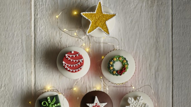 Christmas Decorated Red Sponge Cupcakes on a white background with white Christmas lights
