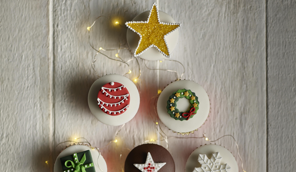 Christmas Decorated Red Sponge Cupcakes on a white background with white Christmas lights
