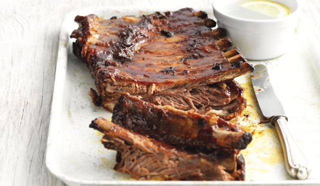 Spiced Barbeque Pork Ribsserved on a white plate with a couple of ribs pulled away
