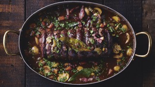 Rolled Venison Casserole served in a metal cassrole dish on a wooden background