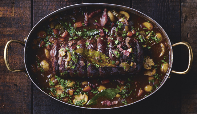 Rolled Venison Casserole served in a metal cassrole dish on a wooden background