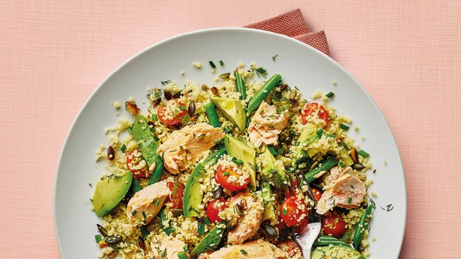 Herby Salmon and Cous Cous Salad served on a white plate, on top of a white table cloth