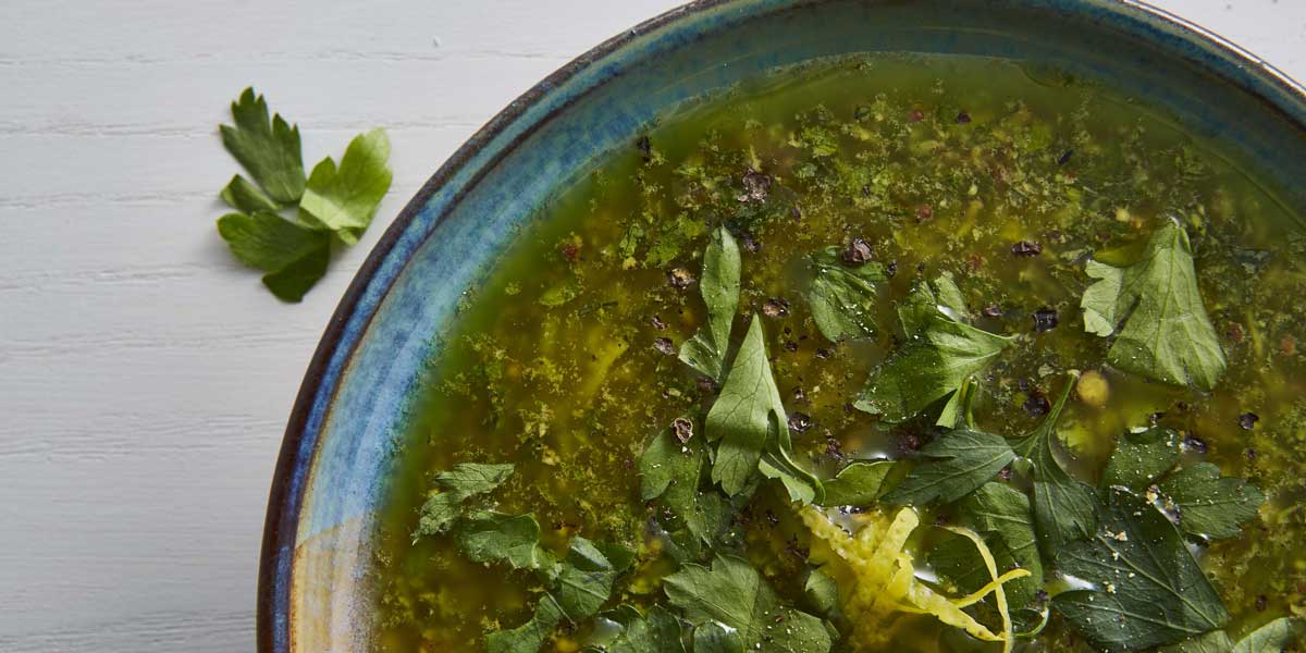 Salsa Verde served in a blue bowl and topped with cracked black pepper
