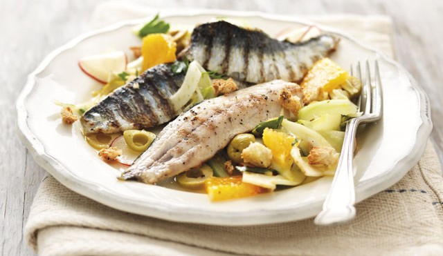 Sicilian Style Sardines with Orange and Fennel Salad served on a white plate topped with green olives and dill