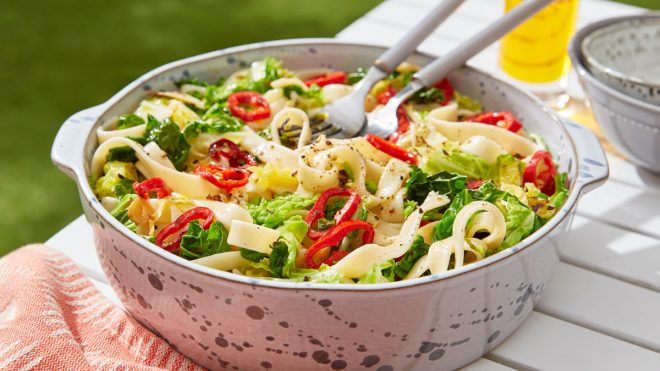 Savoy Cabbage, Red Chilli and Lemon Oil Pasta served in a in a white bowl with two forks