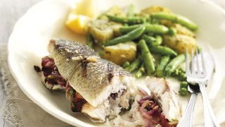 Sea Bass Filled with Fennel, Chilli and Lemon with Summer Vegetables served on a white plate with green beans and new potatoes