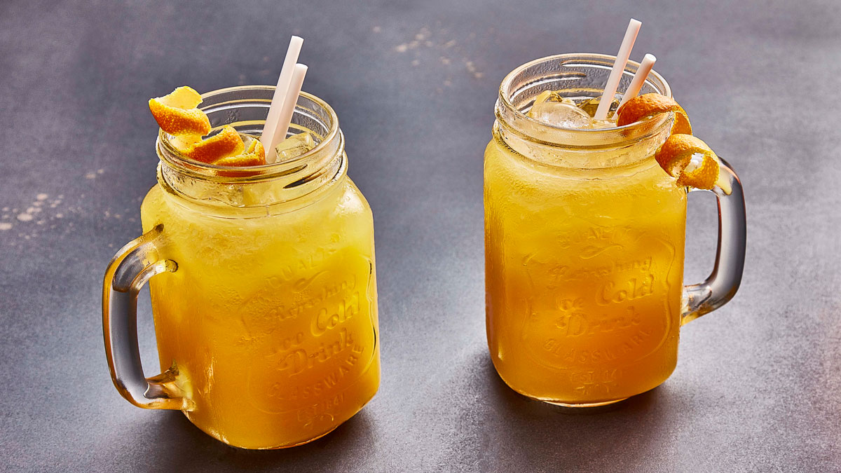 Sicillian Sunset Cocktail served in glass jars, with orange peel garnish