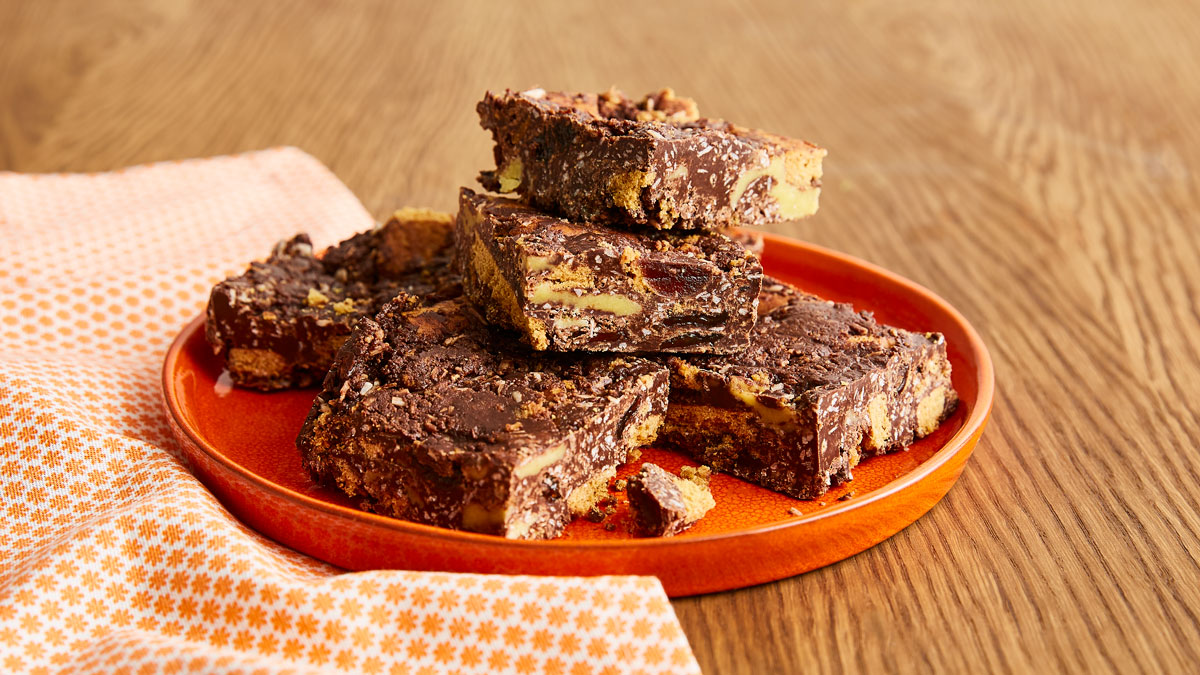 Simnel Cake Tiffin cut in to pieces and served on an orange plate