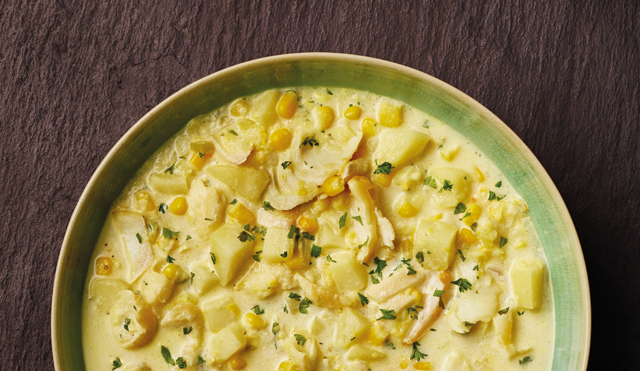 Smoked Haddock and Sweetcorn Chowder served in a green bowl topped with parsley