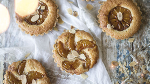 Four Spiced Caramel Clementine and Frangipane Tarts topped with flaked almonds