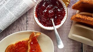 Strawberry and Prosecco Jam served in a white bowl and spread on toast slices