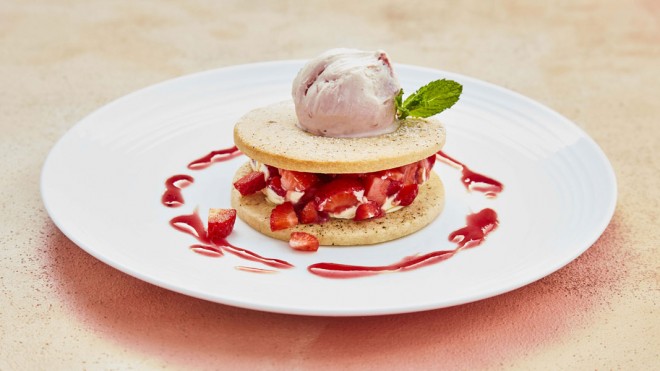 Black Pepper Strawberry Shortbread Sandwich served on a white plate, topped with ice cream with strawberry sauce drizzled