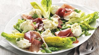 Summer Green Salad with Mozzarella and Parma Ham served on a white plate