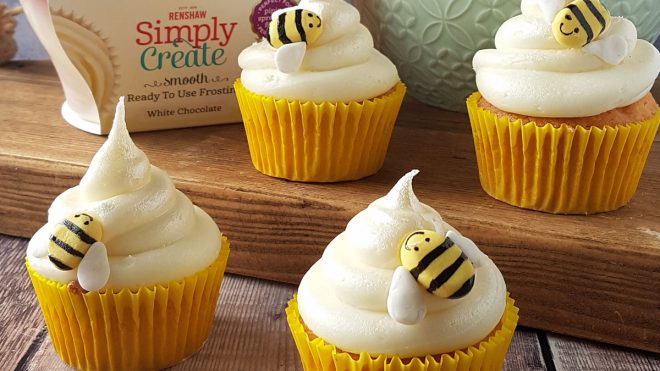 Honey White Chocolate Cupcakes served on a wooden board with decorative bees