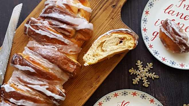 Cinnamon and Cardamom Bread drizzled with icing, served ona wooden board and sliced