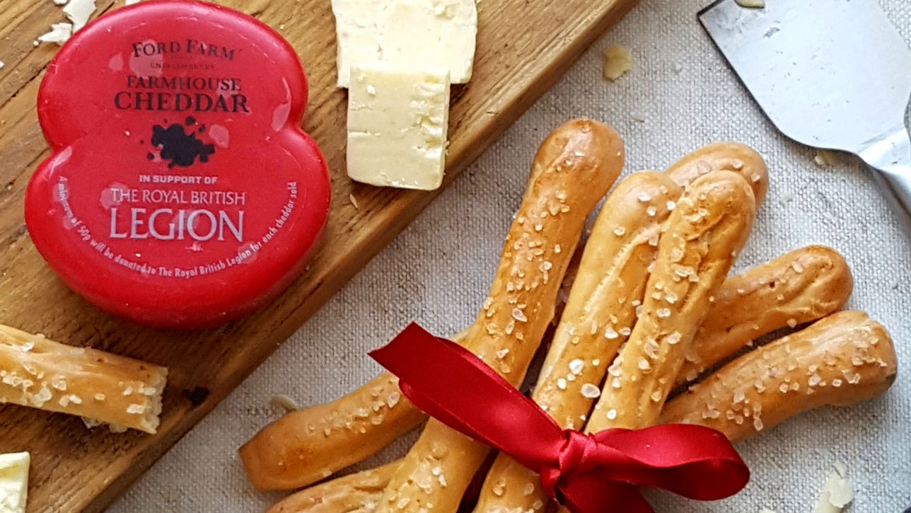 Cheddar Grissini served on a wooden board, tied with a red ribbon