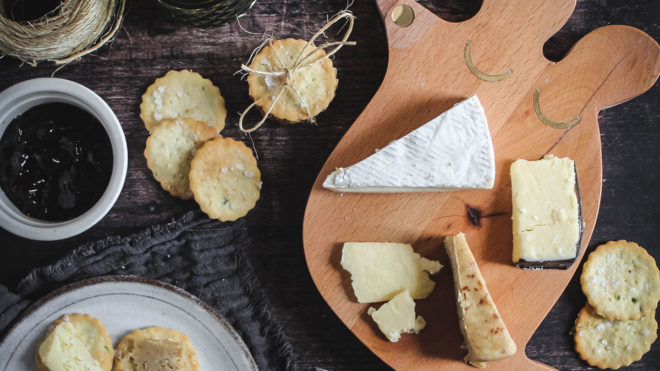 Chive Crackers served on a wooden cheese board with a selection of cheese and chutneys