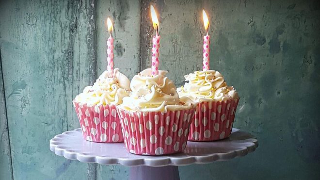 Gluten and Dairy Free Cupcakes served on a purple cake dish with candles in the top