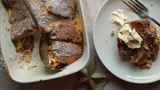 Panettone Pudding served in a baking dish, with a portion removed and placed in a bowl