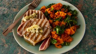 Grilled Tuna Steaks with Lemon Caper Butter and Autumn Mash served on a blue plate