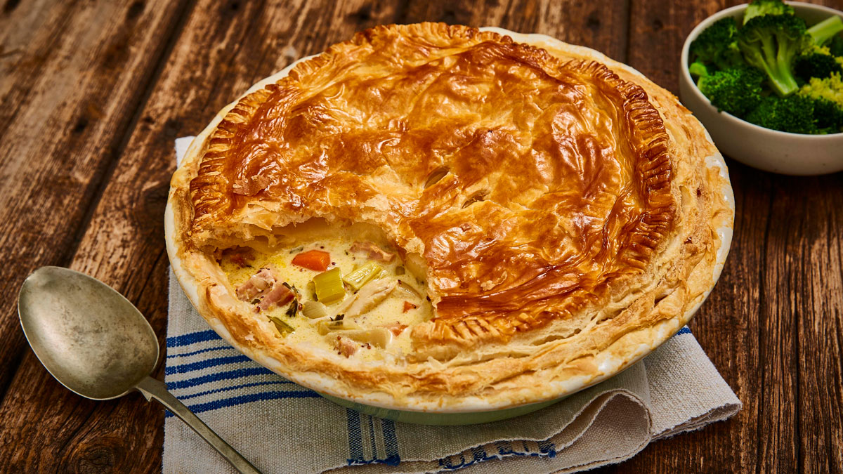 Turkey, Leek and Ham Leftovers Pot Pie served in a pie dish with some of the top removed to see the filling