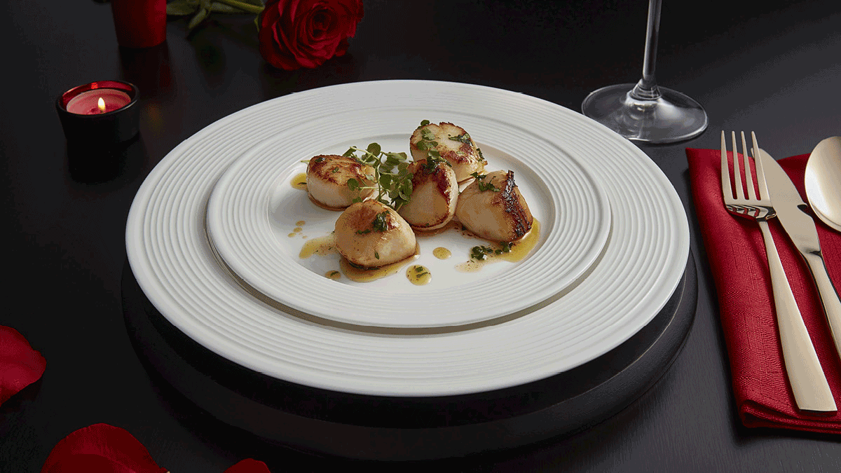 Pan Fried Scallops served on a white plate