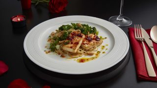 Baked Chilli Tofu, Kale and Sesame Noodles served on a white plate