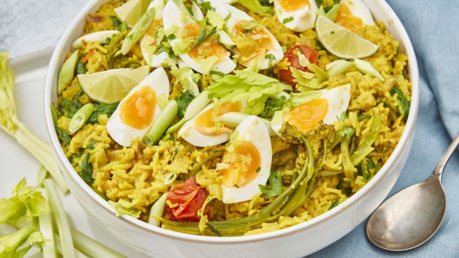 Vegeree served in a white bowl topped with spring onions and parsley