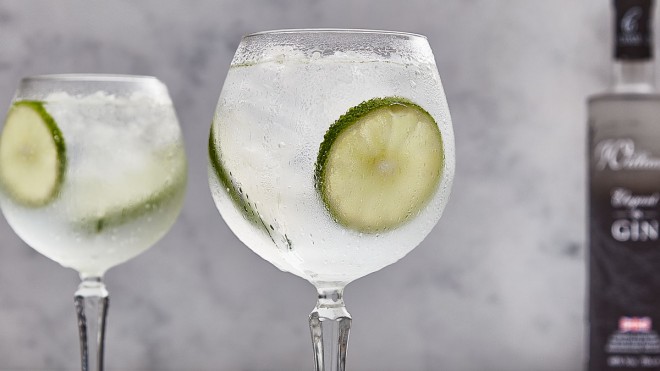 A Very Elegant Gin and Tonic, served in a gin glass with sliced limes