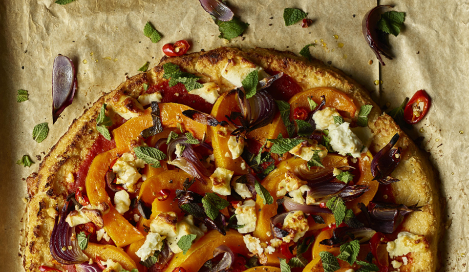 Gluten Free Winter Vegetable and Feta Tart served on baking parchment sprinkled with chopped mint