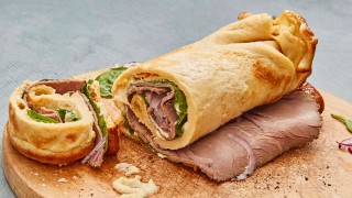 Yorkshire Wrap with Beef and Horseradish served on a wooden board and sliced